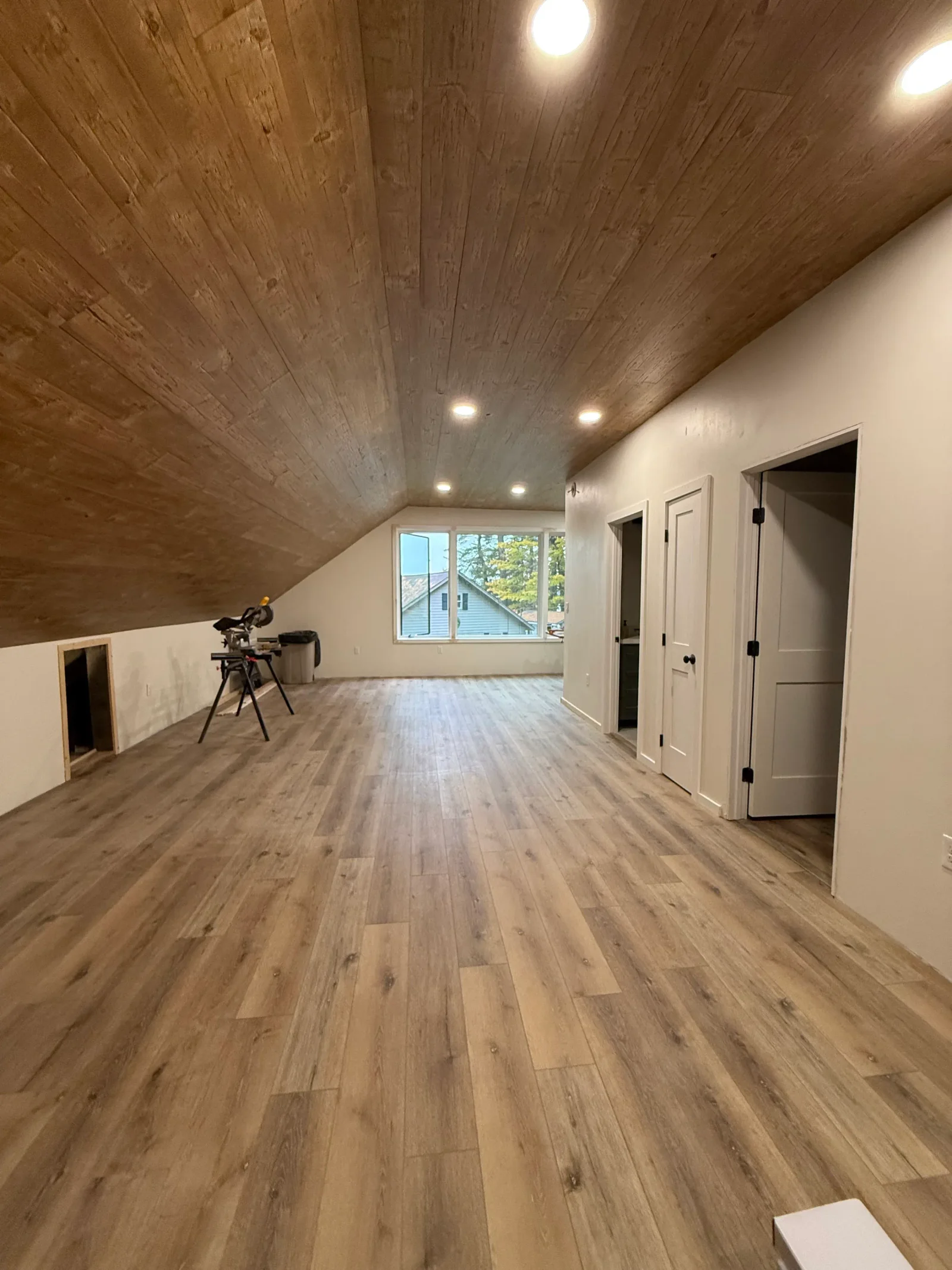 Carpenter measuring and installing wood trim in a home in Lyman, Maine